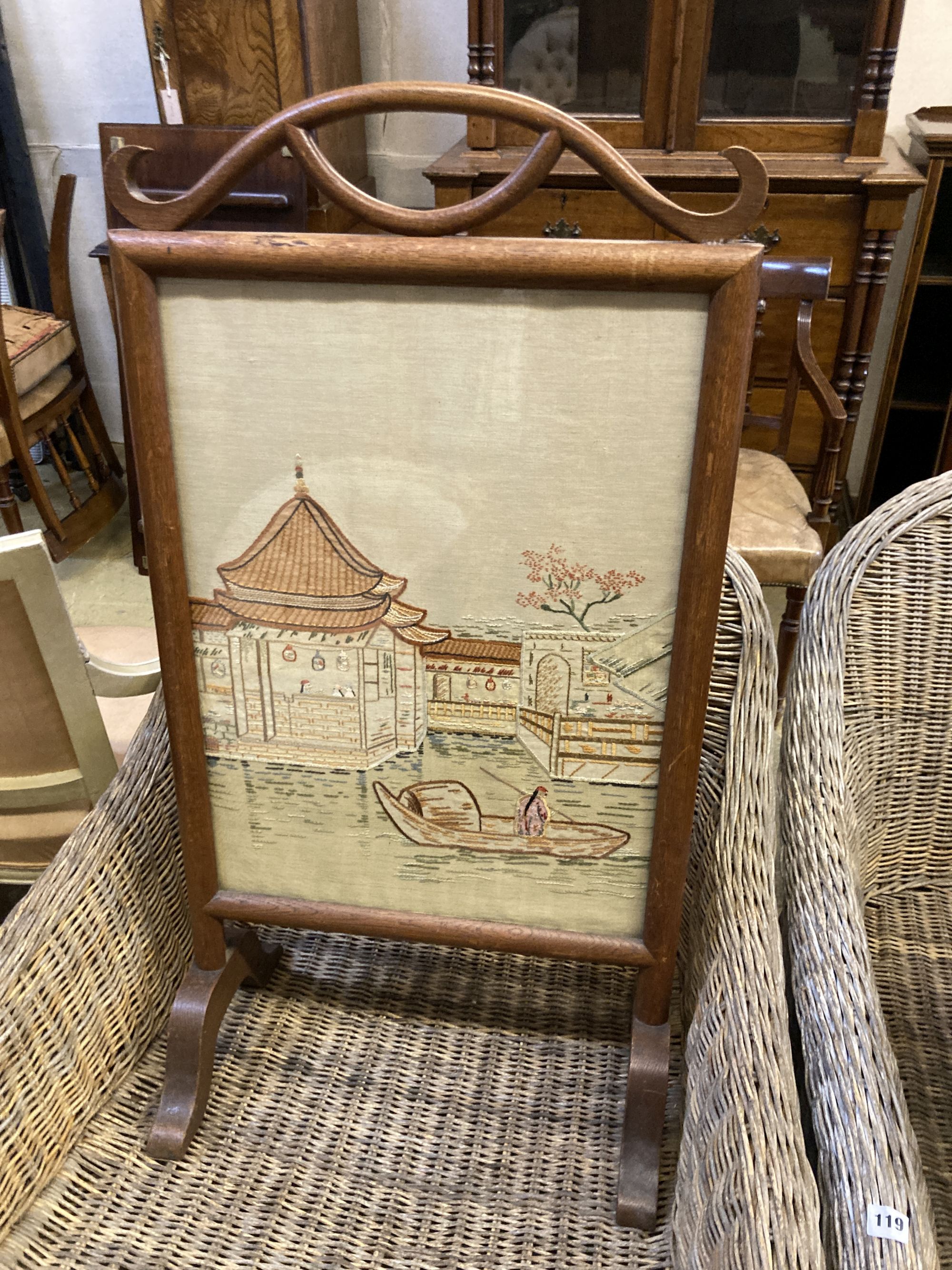 An Arts & Crafts rectangular chip carved oak stool, width 43cm, depth 34cm, height 38cm, together with an embroidered firescreen